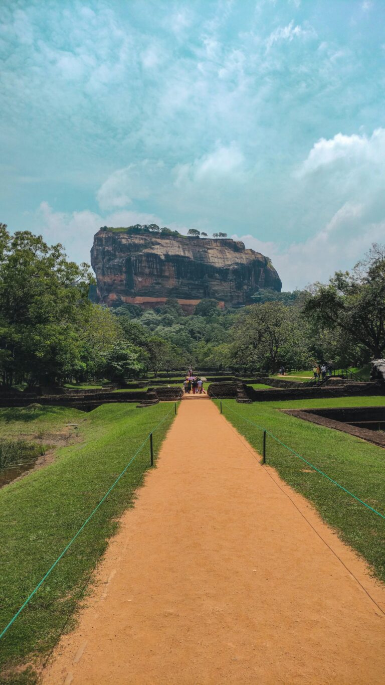 A straight path through green lawns leading to Sigiriya Rock